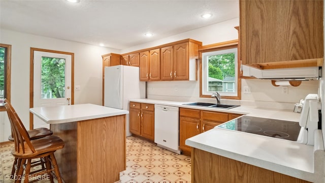 1105 E Henderson Pl, Indianola, IA 50125 - kitchen featuring white appliances, a sink, a kitchen breakfast bar, light countertops, and light floors