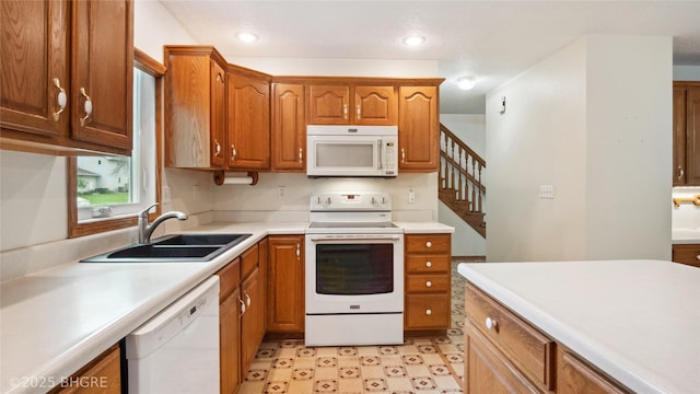 1105 E Henderson Pl, Indianola, IA 50125 - kitchen featuring white appliances, a sink, light countertops, light flooring, and brown cabinetry
