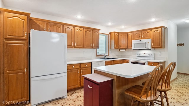 1105 E Henderson Pl, Indianola, IA 50125 - kitchen featuring white appliances, light flooring, a sink, light countertops, and recessed lighting