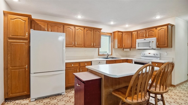 1105 E Henderson Pl, Indianola, IA 50125 - kitchen featuring white appliances, light flooring, a sink, a center island, and light countertops