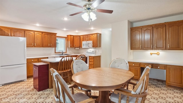 1105 E Henderson Pl, Indianola, IA 50125 - kitchen with white appliances, light flooring, brown cabinets, light countertops, and ceiling fan