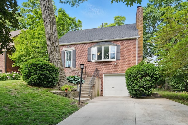 1526 41st Pl, Des Moines, IA 50311 - view of front of house with concrete driveway, a garage, a chimney, a front yard, and brick siding
