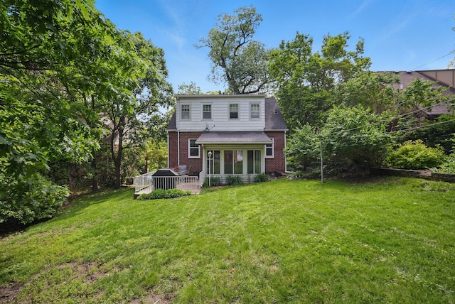 1526 41st Pl, Des Moines, IA 50311 - rear view of property featuring brick siding, a lawn, and a sunroom
