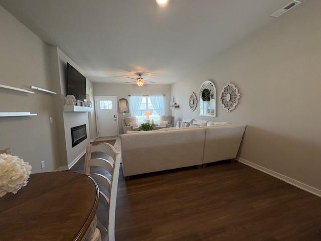 2807 NW 31st St, Ankeny, IA 50023 - living area with a glass covered fireplace, dark wood finished floors, a ceiling fan, and baseboards