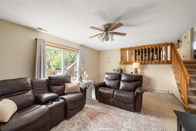 9640 Quail Run, Urbandale, IA 50322 - living room featuring a ceiling fan, stairs, carpet, and a textured ceiling