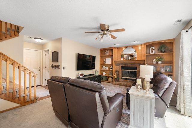 9640 Quail Run, Urbandale, IA 50322 - living room featuring stairway, a ceiling fan, light carpet, a brick fireplace, and built in shelves
