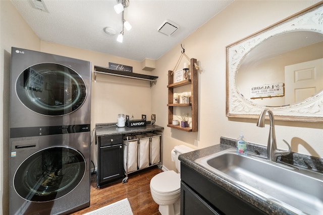 9640 Quail Run, Urbandale, IA 50322 - laundry area with estacked washer and dryer and dark wood-style floors