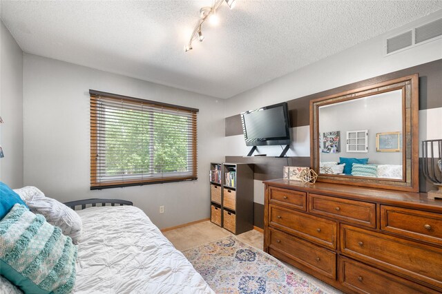 9640 Quail Run, Urbandale, IA 50322 - bedroom featuring a textured ceiling, light carpet, and baseboards