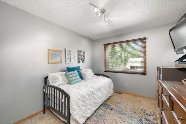 9640 Quail Run, Urbandale, IA 50322 - bedroom with baseboards, a textured ceiling, light colored carpet, and track lighting