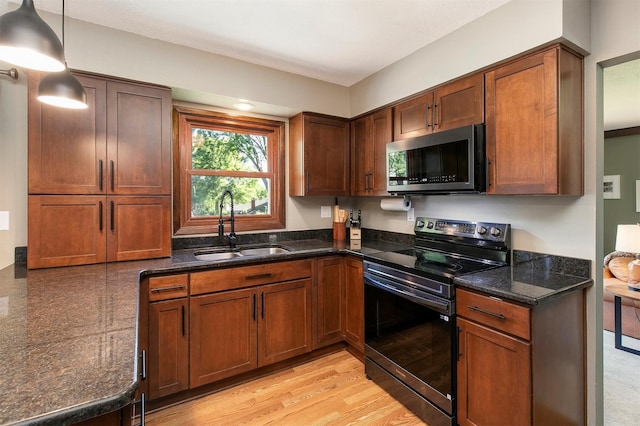 9873 Colby Ave, Clive, IA 50325 - kitchen with stainless steel microwave, black range with electric cooktop, a sink, dark stone countertops, and hanging light fixtures