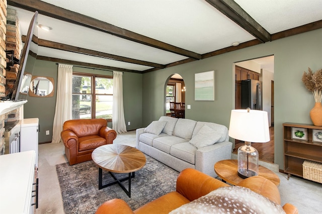 9873 Colby Ave, Clive, IA 50325 - living area featuring arched walkways, beam ceiling, light colored carpet, and baseboards