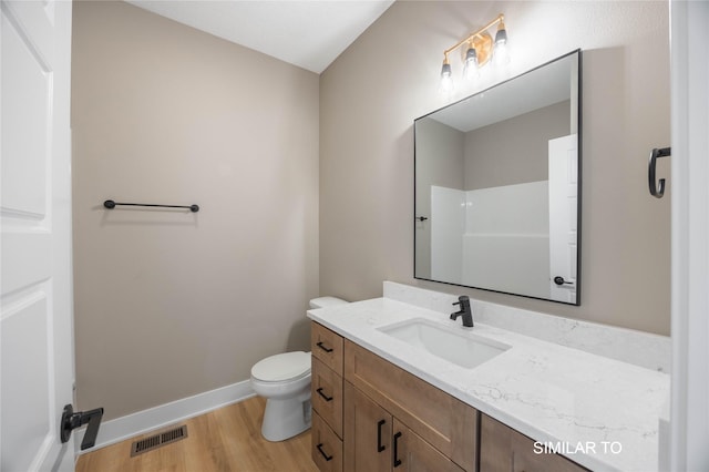 610 Ellis Cir, Adel, IA 50003 - full bathroom featuring vanity, wood finished floors, toilet, a shower, and baseboards