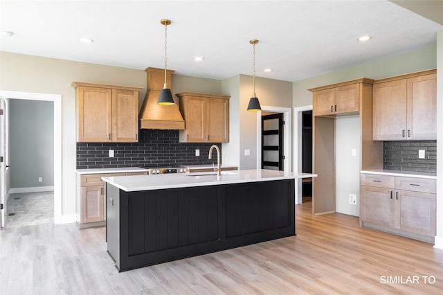 610 Ellis Cir, Adel, IA 50003 - kitchen with a sink, custom range hood, light countertops, light wood-style floors, and backsplash