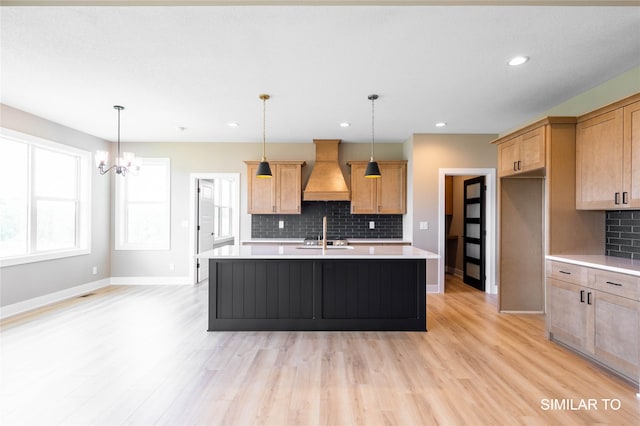 610 Ellis Cir, Adel, IA 50003 - kitchen featuring custom exhaust hood, light countertops, tasteful backsplash, light wood-style floors, and recessed lighting