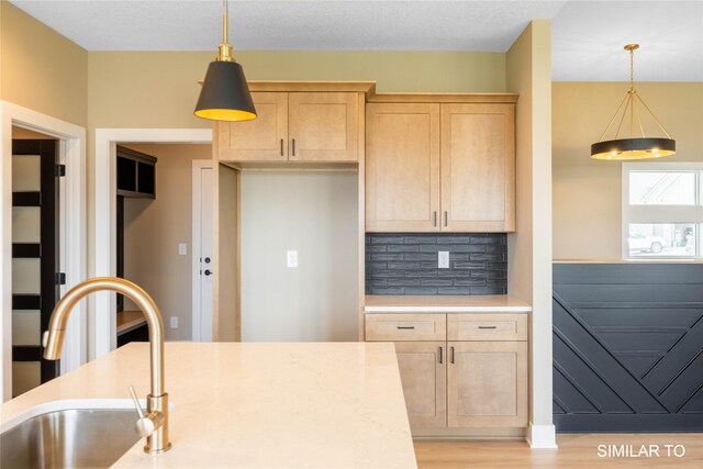 610 Ellis Cir, Adel, IA 50003 - kitchen featuring light brown cabinets, backsplash, a sink, and pendant lighting