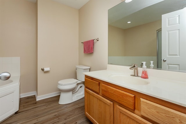 601 Orchard Hills Dr Unit 5011, Norwalk, IA 50211 - bathroom featuring vanity, wood finished floors, toilet, baseboards, and a garden tub