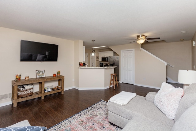 601 Orchard Hills Dr Unit 5011, Norwalk, IA 50211 - living area featuring dark wood-type flooring, a ceiling fan, baseboards, and stairway