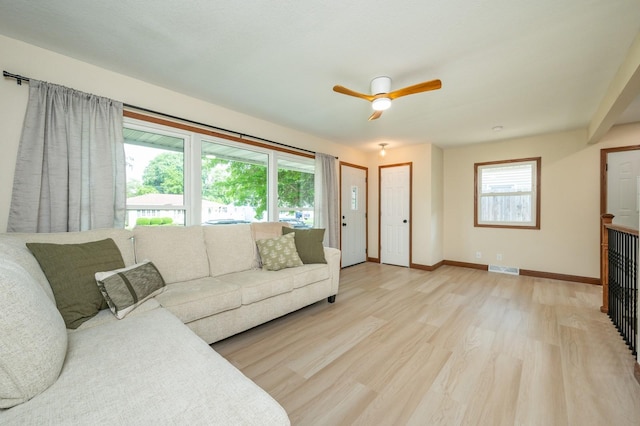 2607 E 39th St, Des Moines, IA 50317 - living room featuring healthy amount of natural light, light wood-type flooring, a ceiling fan, and baseboards