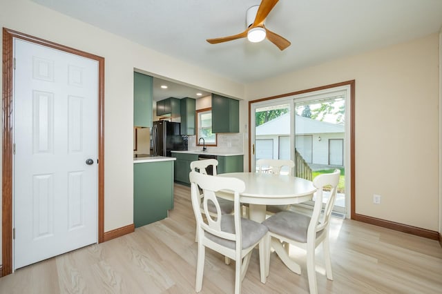2607 E 39th St, Des Moines, IA 50317 - dining room with a ceiling fan, light wood-style floors, and baseboards