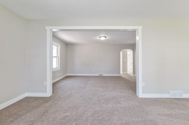 3811 E 30th St, Des Moines, IA 50317 - carpeted spare room featuring arched walkways and baseboards