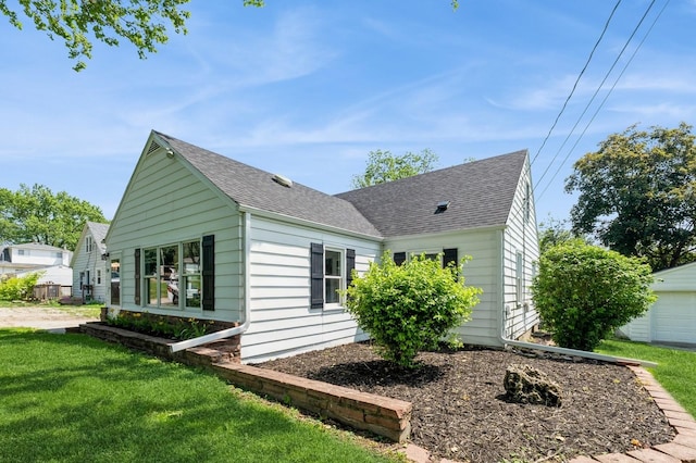 3811 E 30th St, Des Moines, IA 50317 - view of side of home featuring roof with shingles and a lawn