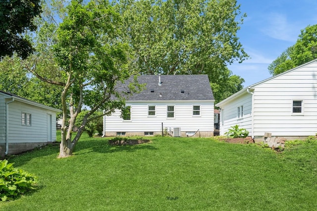 3811 E 30th St, Des Moines, IA 50317 - back of house featuring a lawn, central AC unit, and a shingled roof