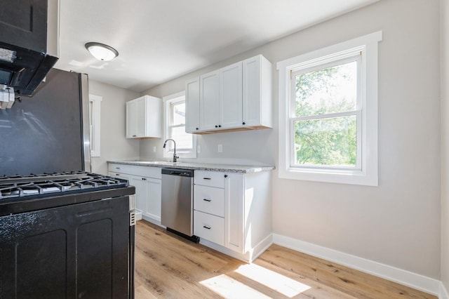 3811 E 30th St, Des Moines, IA 50317 - kitchen with dishwasher, light wood-type flooring, black range with gas stovetop, baseboards, and white cabinets