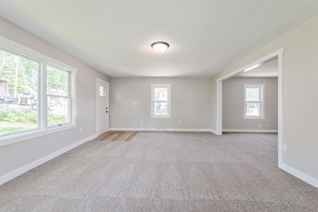 3811 E 30th St, Des Moines, IA 50317 - spare room featuring healthy amount of natural light, light colored carpet, and baseboards