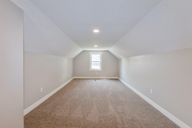 3811 E 30th St, Des Moines, IA 50317 - additional living space with light carpet, baseboards, lofted ceiling, and recessed lighting