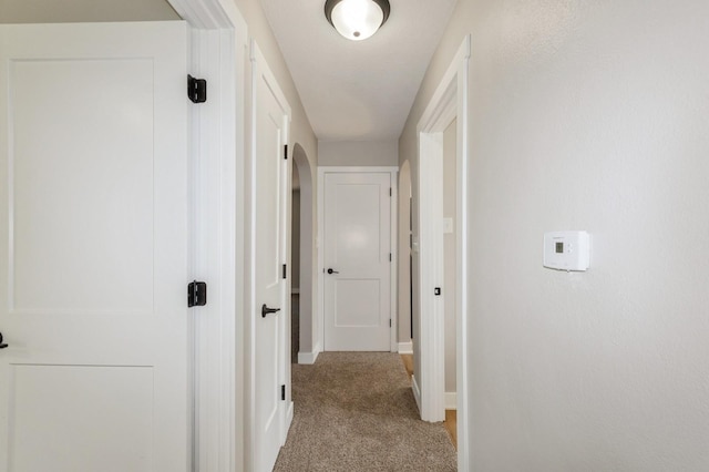 3811 E 30th St, Des Moines, IA 50317 - hallway featuring light carpet, baseboards, and arched walkways