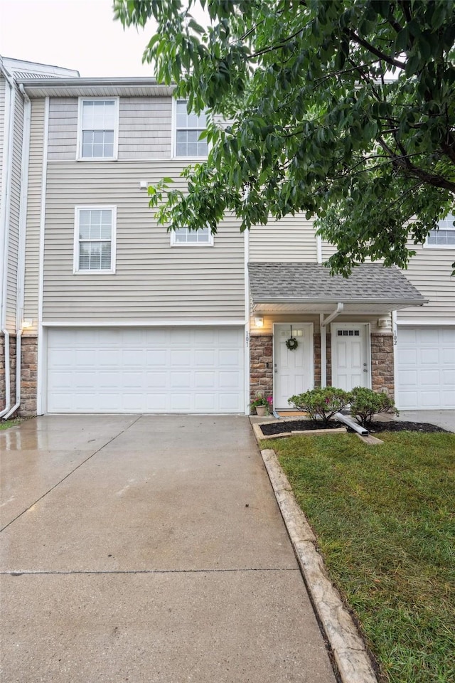 2150 NE 18th St Unit 101, Grimes, IA 50111 - view of front of property featuring stone siding, driveway, and a garage