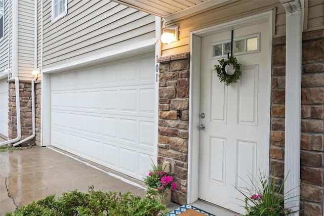 2150 NE 18th St Unit 101, Grimes, IA 50111 - doorway to property with a garage, brick siding, and stone siding