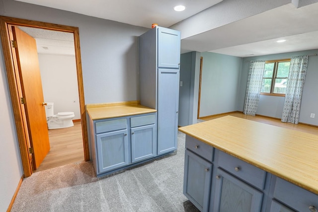 102 Jackson St, Pella, IA 50219 - kitchen with blue cabinetry, light countertops, light carpet, and recessed lighting