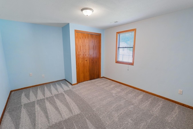 102 Jackson St, Pella, IA 50219 - unfurnished bedroom featuring baseboards, a closet, and light carpet