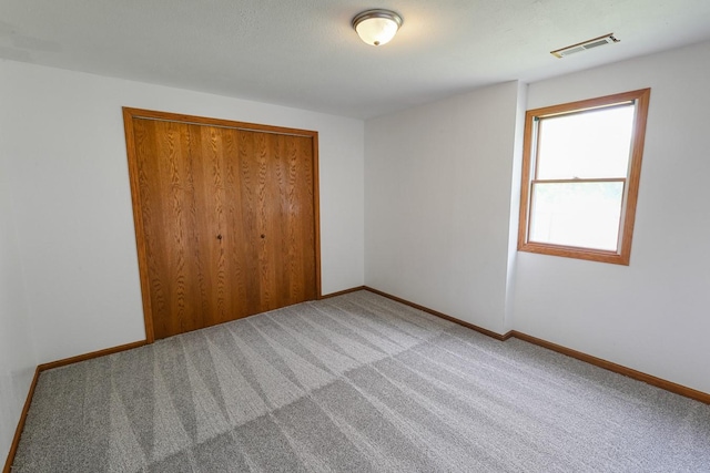 102 Jackson St, Pella, IA 50219 - unfurnished bedroom with light colored carpet, baseboards, and a closet