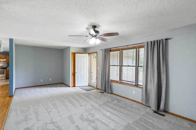 102 Jackson St, Pella, IA 50219 - spare room with baseboards, ceiling fan, light carpet, and a textured ceiling