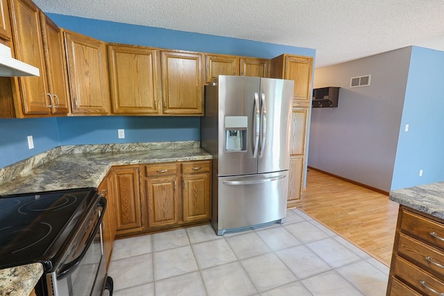 102 Jackson St, Pella, IA 50219 - kitchen featuring stainless steel fridge with ice dispenser, brown cabinets, range hood, a textured ceiling, and range with electric cooktop