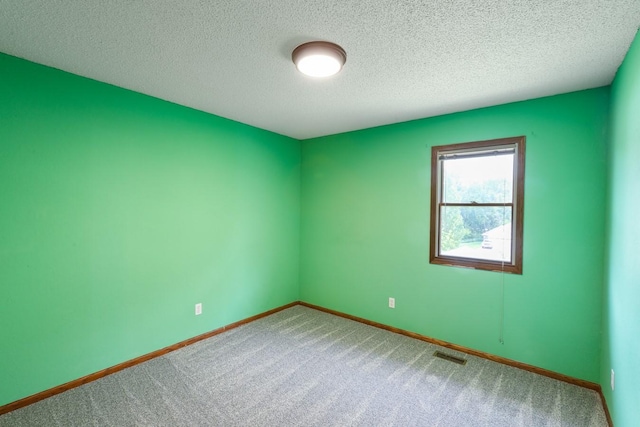 102 Jackson St, Pella, IA 50219 - empty room featuring carpet, baseboards, and a textured ceiling