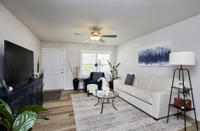 134 Aspen Dr, Norwalk, IA 50211 - living area featuring light wood-style flooring, a ceiling fan, and baseboards