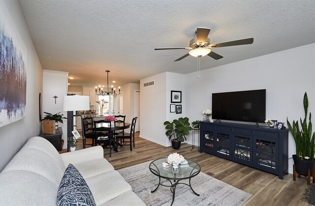 134 Aspen Dr, Norwalk, IA 50211 - living area featuring wood finished floors, ceiling fan, a chandelier, a textured ceiling, and baseboards