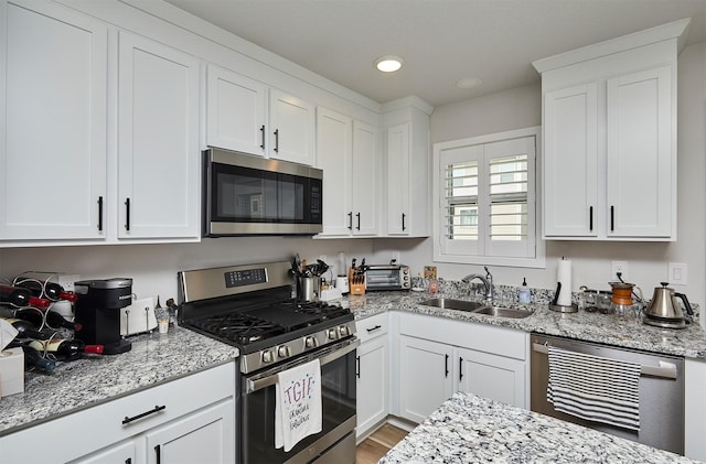 134 Aspen Dr, Norwalk, IA 50211 - kitchen with appliances with stainless steel finishes, a sink, white cabinets, light stone countertops, and recessed lighting