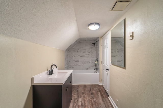 2336 E 13th St, Des Moines, IA 50316 - bathroom with a textured ceiling, vanity, wood finished floors, a textured wall, and bathing tub / shower combination