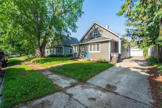 2336 E 13th St, Des Moines, IA 50316 - bungalow-style house with an outdoor structure, a chimney, a front yard, and a garage