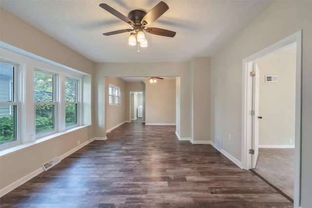 2336 E 13th St, Des Moines, IA 50316 - spare room with dark wood-style flooring, ceiling fan, baseboards, and a textured ceiling