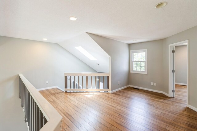 2405 81st Cir, Urbandale, IA 50322 - unfurnished room featuring a skylight, recessed lighting, and wood-type flooring