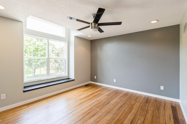 2405 81st Cir, Urbandale, IA 50322 - unfurnished room with a textured ceiling, plenty of natural light, wood finished floors, ceiling fan, and recessed lighting