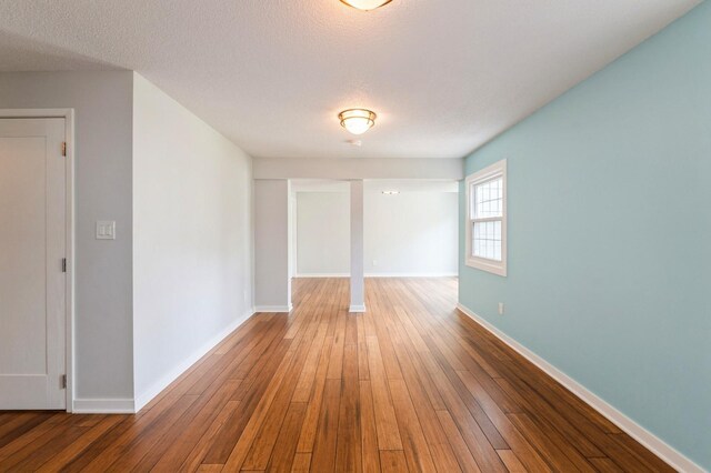 2405 81st Cir, Urbandale, IA 50322 - spare room featuring wood-type flooring and a textured ceiling