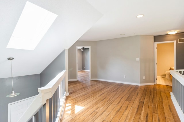 2405 81st Cir, Urbandale, IA 50322 - hall featuring an upstairs landing, a skylight, light wood-type flooring, and recessed lighting