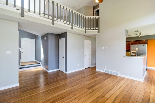 2405 81st Cir, Urbandale, IA 50322 - unfurnished living room with a high ceiling and wood-type flooring
