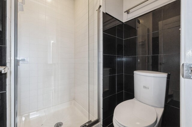 2405 81st Cir, Urbandale, IA 50322 - bathroom featuring a stall shower and tile walls